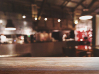 Fototapeta na wymiar Empty wood table top and blurred bokeh cafe and coffee shop interior background with vintage filter - can used for display or montage your products.