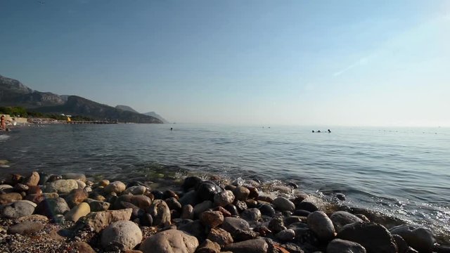 Turkey - August 2017, Kemer, Beldibi: Stone beach with sea, mountains on blue sunset background. Tropical summer landscape