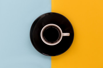 Coffee cup + saucer on yellow and blue background