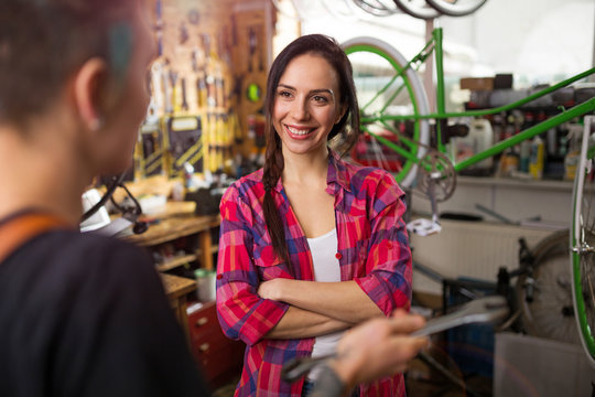 Two young women working in a bicycle repair shop
