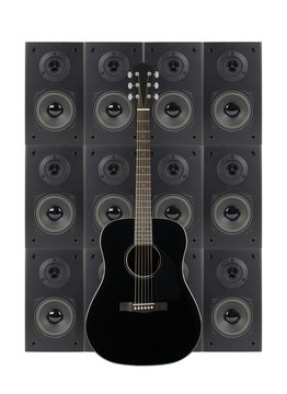 Music and sound - Black guitar on a loudspeaker enclosure background. Isolated