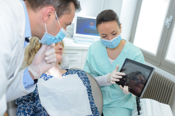 female dentist with tablet pc and male patient