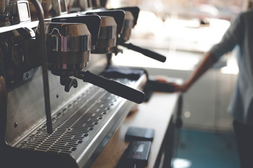 The handle of the coffee machine in the morning in a cafe on the background of the baristas wipe cloth table