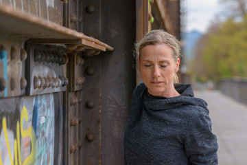 Thoughtful attractive blond woman on a bridge