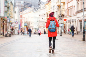 Happy young urban woman walking in european city