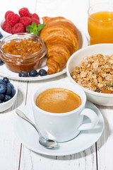 delicious breakfast with croissant and fresh berries on white wooden table, vertical