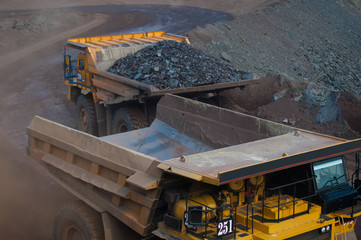 shipping. mining, delivery, transportation, loading, dump truck, truck, huge, heavy. Mining dump truck transports rock, iron ore along the side of the quarry.