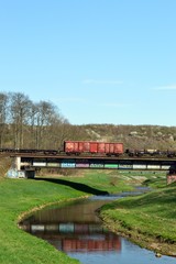 Fototapeta na wymiar Railway bridge, train goes over a bridge, green landscape with river in germany, at Leipzig