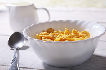 Corn Flakes cereal in a bowl and glass with milk. Morning breakfast.