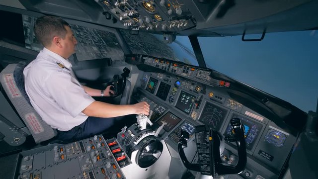 One pilot turns a plane to the left, sitting in a flight simulator. 4K.