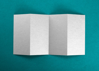 Mockup of opened four fold brochure at green background.