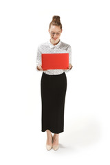 Full length portrait of a smiling female teacher holding a laptop isolated against white background