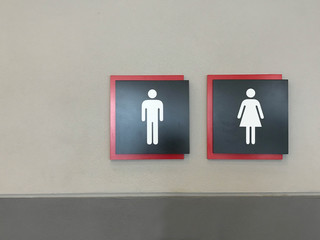Modern toilet sign on gray cement wall