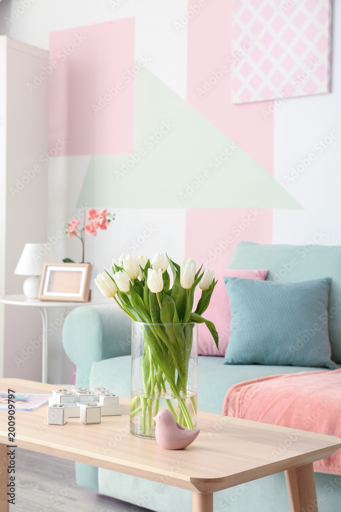 Wall mural wooden table with bouquet of tulips near sofa in living room