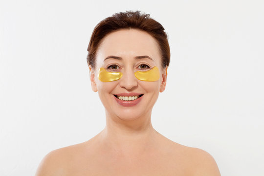 Middle age woman beauty face with wrinkles and mask under eyes isolated on white background. Spa concept.Copy space. Menopause , anti aging collagen patches on fresh facial skin. High resolution.