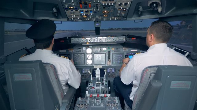 Pilots take the plane off in a flight simulator. 4K.