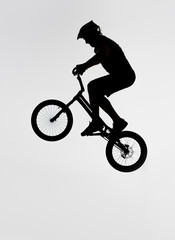 Fototapeta na wymiar silhouette of trial biker jumping on bicycle on white