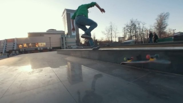 Skateboarder failed tricks on the ramp outdoors in sunset