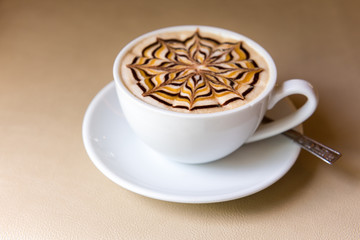 Latte art coffee cup on leather table