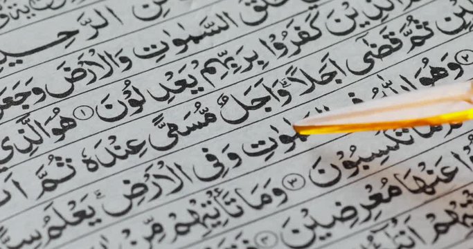 Closeup of somebody reading Koran and using pointer stick for pointing the Koran letters. Shot in 4k resolution