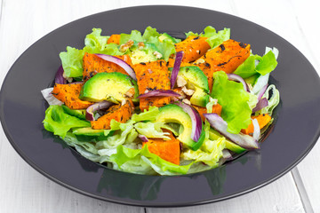 Delicious salad with avocado, pumpkin, greens