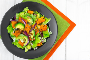 Delicious salad with avocado, pumpkin, greens