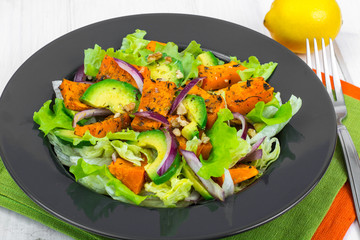 Delicious salad with avocado, pumpkin, greens