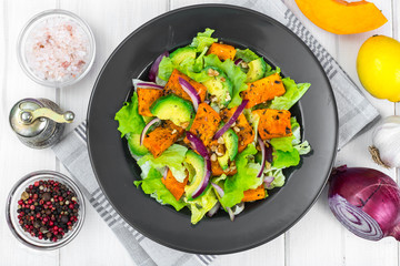 Delicious salad with avocado, pumpkin, greens