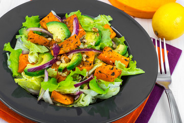 Delicious salad with avocado, pumpkin, greens