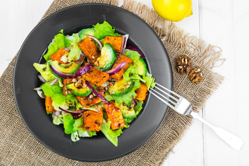 Delicious salad with avocado, pumpkin, greens