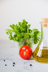 Olive oil, green salad lettuce and fresh tomato