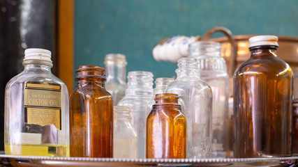 A collection of antique glass bottles one of which has castor oil with the label claiming that it is tasteless.