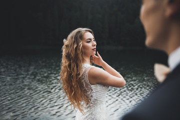 Beautiful gorgeous bride posing to groom and having fun, luxury ceremony at mountains with amazing view, space for text, wedding couple