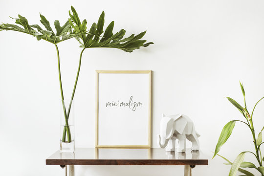 The stylish interior with mock up poster frame, leafs and elephant sculpture. The minimalizm concept of space. 