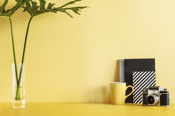 Creative desk with copy space. Empty yellow wall. Minimalistic concept.
