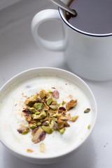 Joghurt mit Pistazien zum Frühstück mit Becher Ceylon Assam Tee