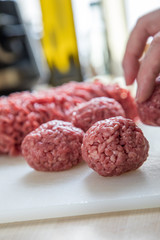 Frau bei Zubereitung von Hackbällchen aus Schwein und Rind in Küche