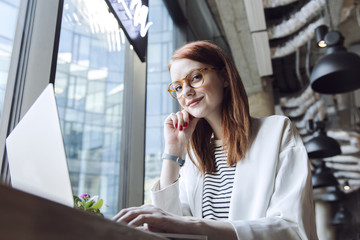 Business woman working in modern coworking office using personal laptop, computer and phone. Modern...