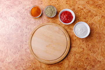 Empty cutting board on table with different spicies