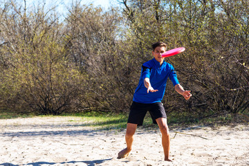 Teenage boy enthusiastically playing frisbee