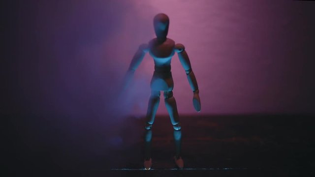 wooden man on black background with backlight from below