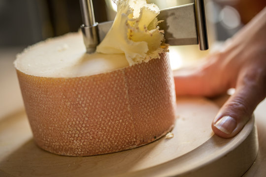Frau schneidet Schweizer Tête de Moine K&auml;se Rosette auf Girolle in K&uuml;che