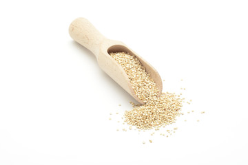 Fototapeta na wymiar Semillas de quinoa cruda en una cuchara de madera sobre fondo blanco