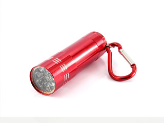 close-up red metallic cylinder flashlight with led bulb and hanging clip carabiner hook loop isolated on white, mini portable torch light for illuminate emergency