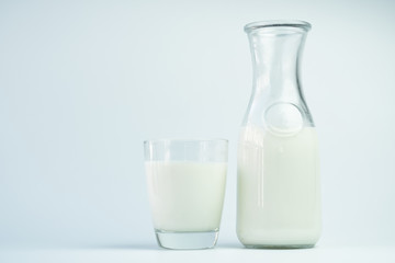 Natural whole milk in a jug and a glass isolated on a white background closeup