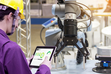 Industry 4.0 Robot concept .Engineers use laptop computers for machine maintenance, automation tools, robot arm at the factory.