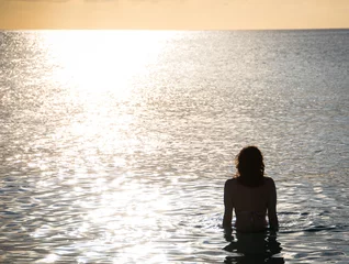 Papier Peint photo autocollant Plage de Seven Mile, Grand Cayman Girl in Ocean Watching Sunset