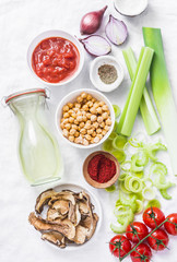 Vegetarian food ingredients for detox lunch. Soup ingredients - chicken broth, celery, leeks, lentils, chickpeas, tomatoes, red onions on a light background, top view. Flat lay