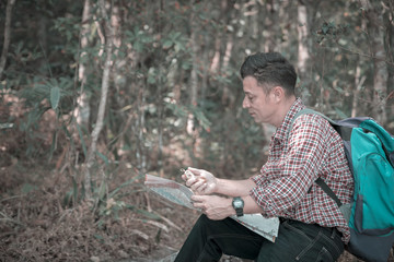 Backpacker looking at map in forest.