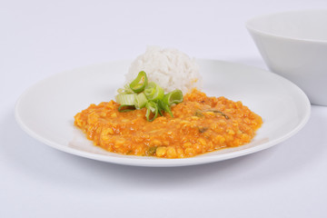 Red lentil in a sauce ansd rice on a white